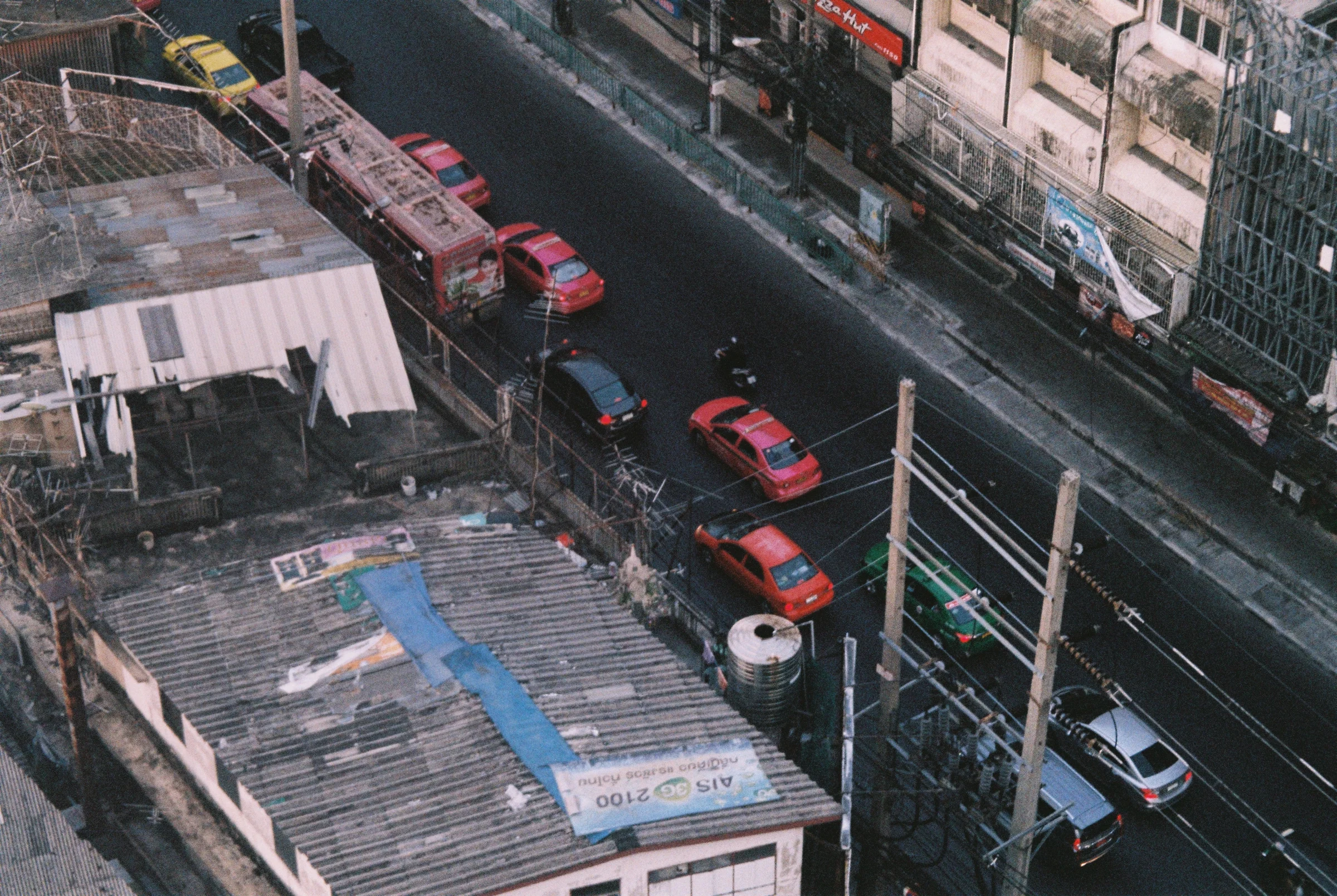Cars and taxis on a city street seen from above in Thailand.